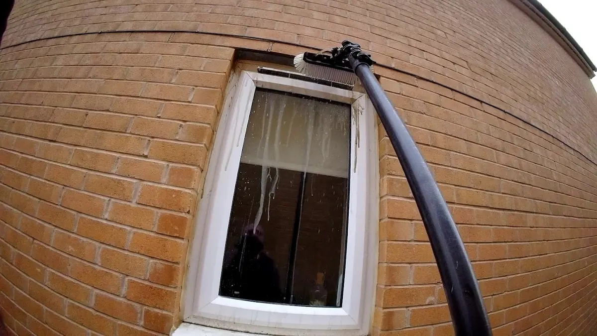 Water-fed pole cleaning window vents during a first clean in Colchester