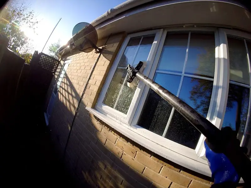 Water-fed pole cleaning a house window in Colchester